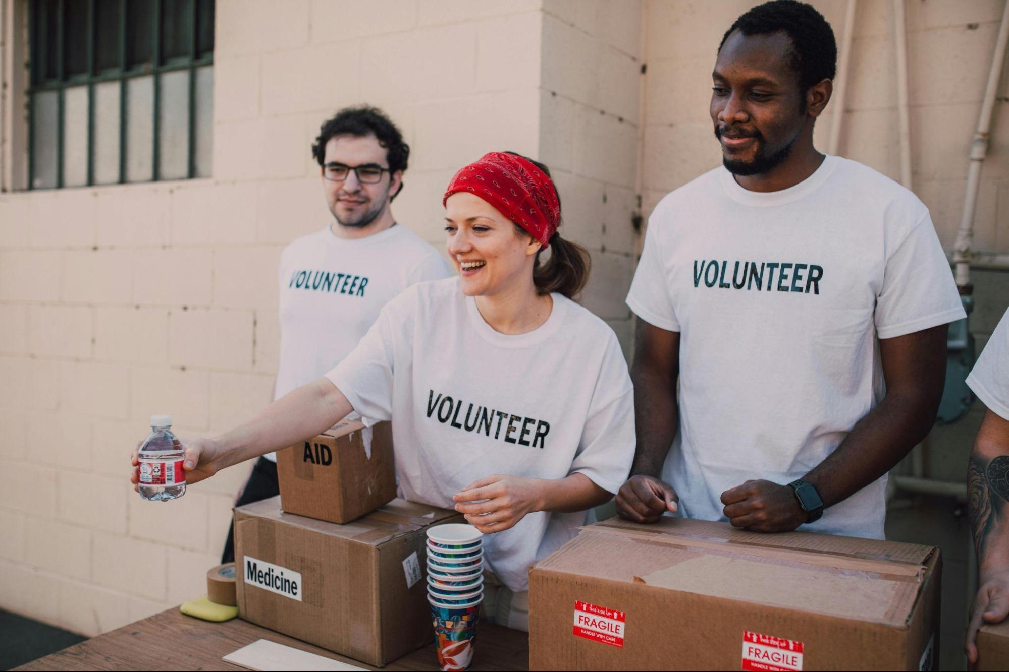 Volunteers distributing aid boxes and water during a community charity drive, reflecting compassion, service, and Lenten devotion.