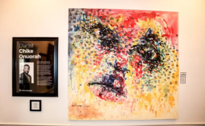 A vibrant African painting by Chike Onuorah at Ovico Gallery, capturing cultural depth and emotional storytelling, accompanied by a biography of the artist, highlighting the gallery’s commitment to authentic African art.