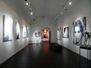 Modern art gallery interior featuring contemporary African paintings and portrait artworks under soft lighting, showcasing Ovico Gallery’s blend of culture, emotion, and visual storytelling.