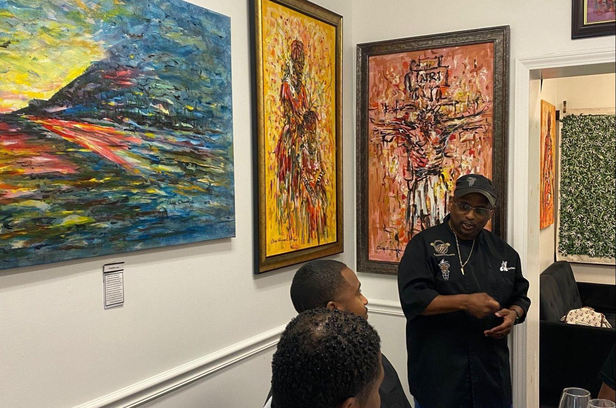 Chef Amadeus, speaking to guests during a private dining event at Ovico Gallery, a wall art gallery known for African contemporary works and fine art prints in St. Augustine.
